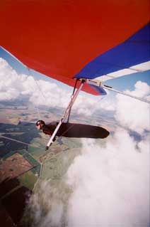 Solo hang gliding above the clouds.